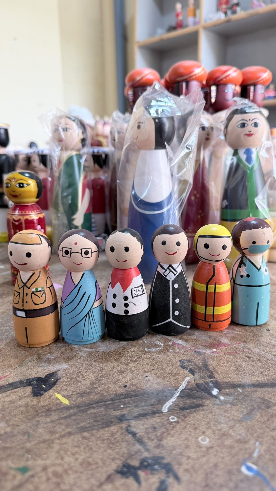 A row of wooden community helper figures painted by hand