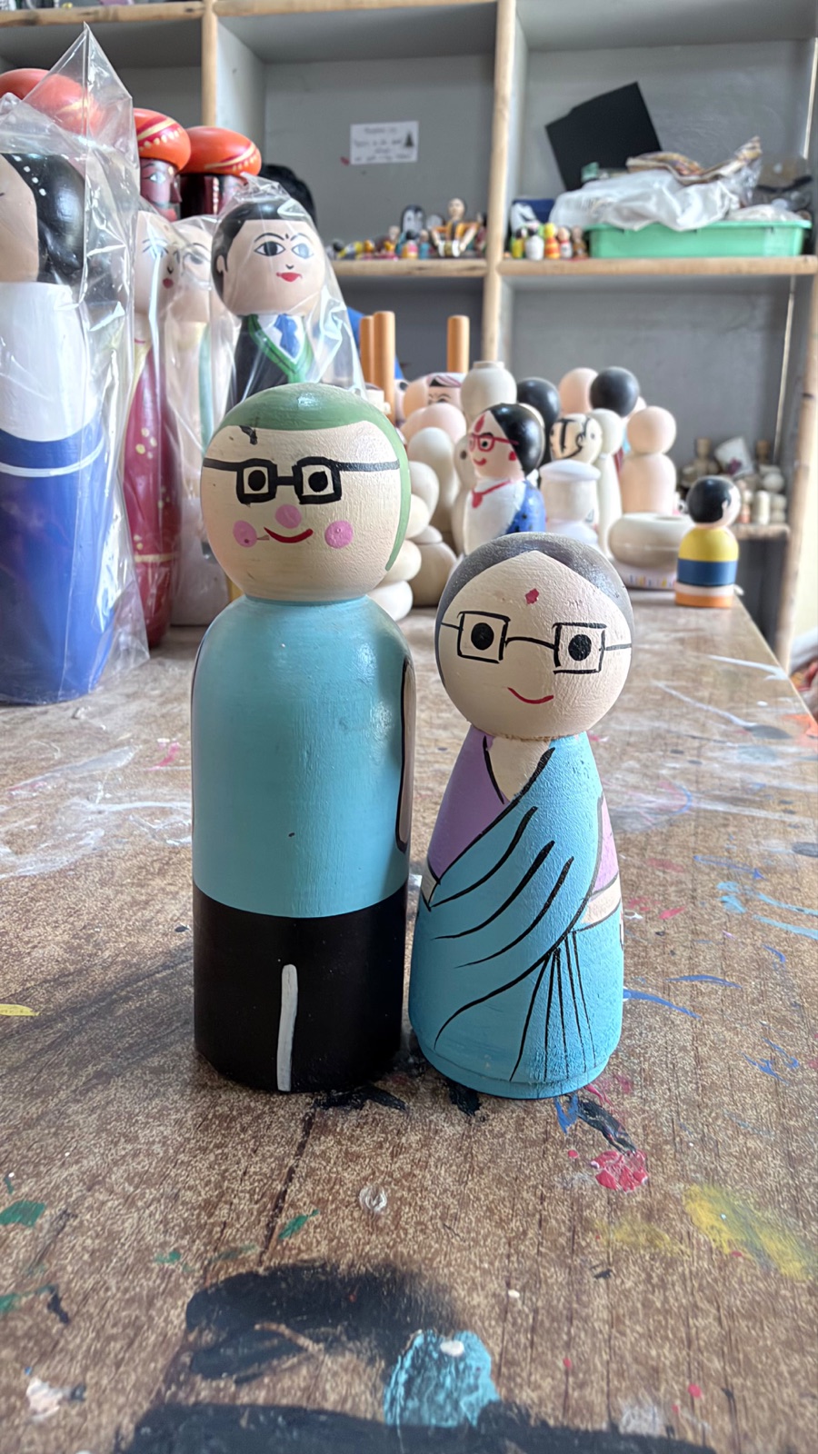 Hand-painted wooden grandparent pair photographed in the maker's workshop