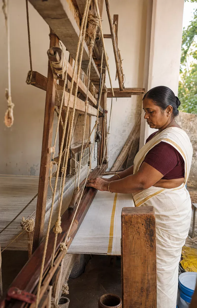 Editorial reconstruction of a Kerala handloom artisan weaving kasavu-bordered cloth